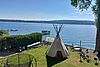 Außengelände der Villa mit Tipi, Trampolin und Blick auf den See